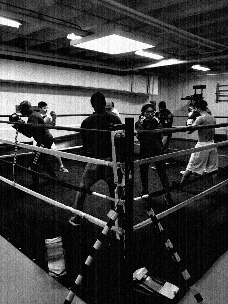 A taped ring corner with ropes on the club floor